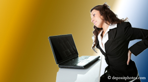 a person Fernandina Beach bending over a computer holding her back due to pain